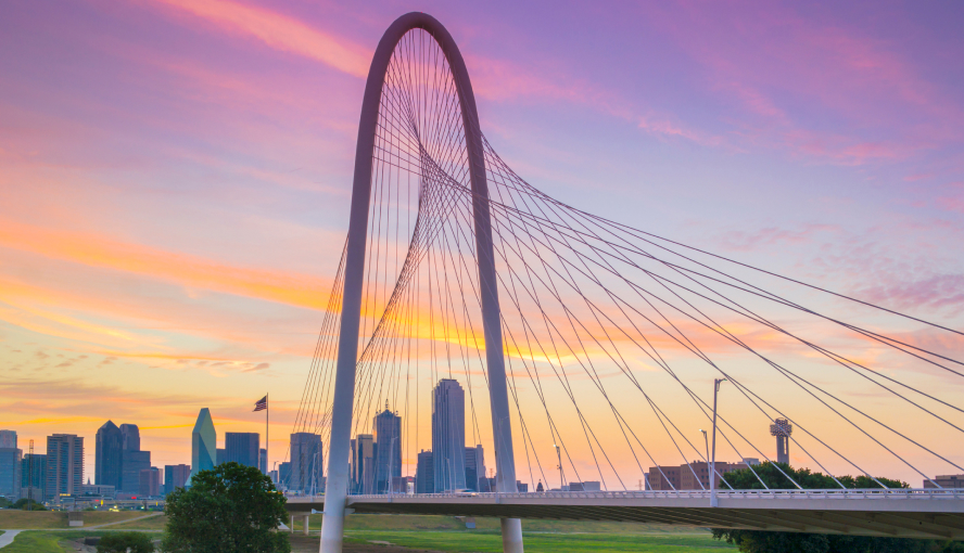 Dallas skyline with Margaret Hunt Hill Bridge at sunset.